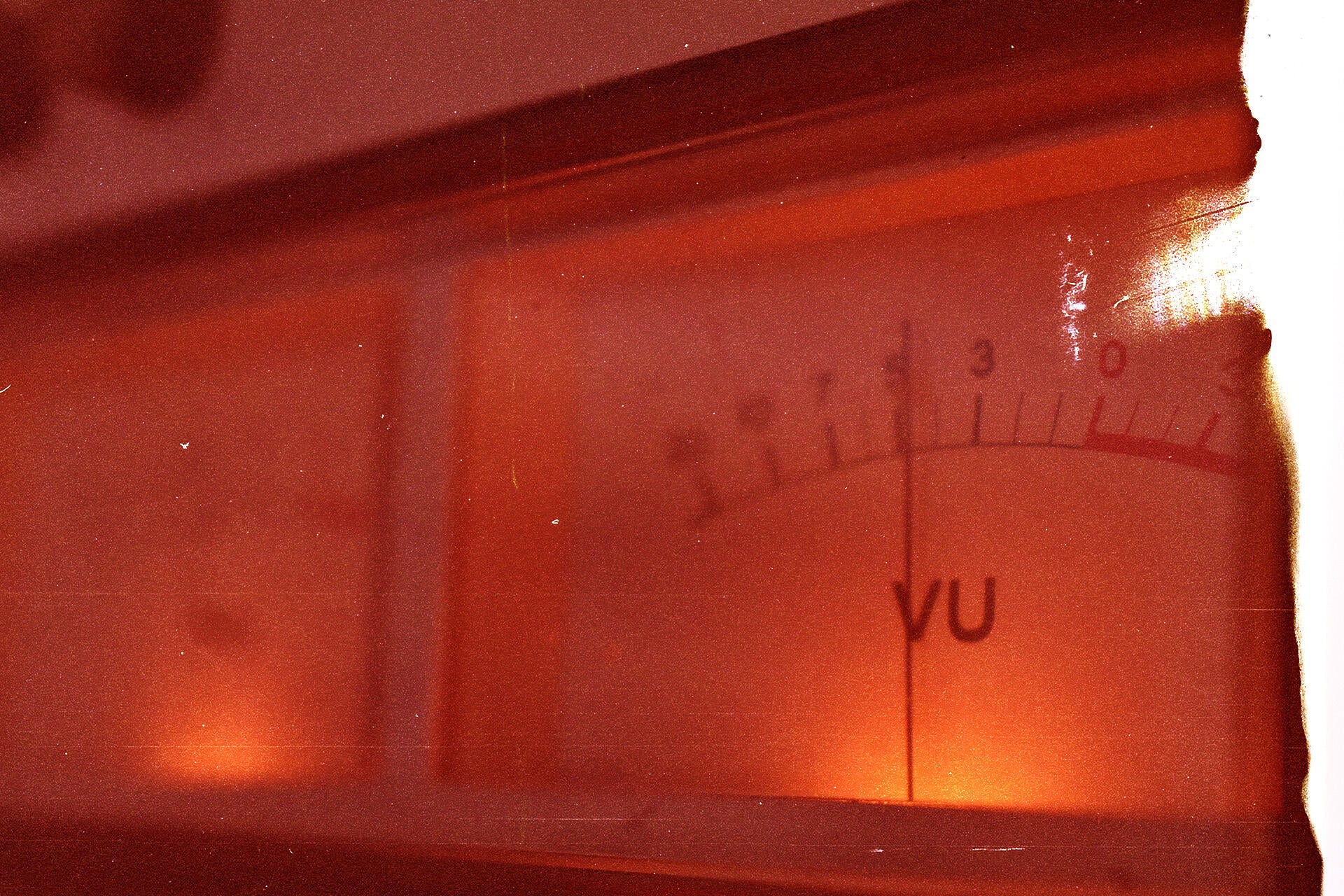 Close-up of a vintage VU meter with a film burn effect, highlighting the warm, analog distortion characteristic of gritty sample packs and retro audio recordings.
