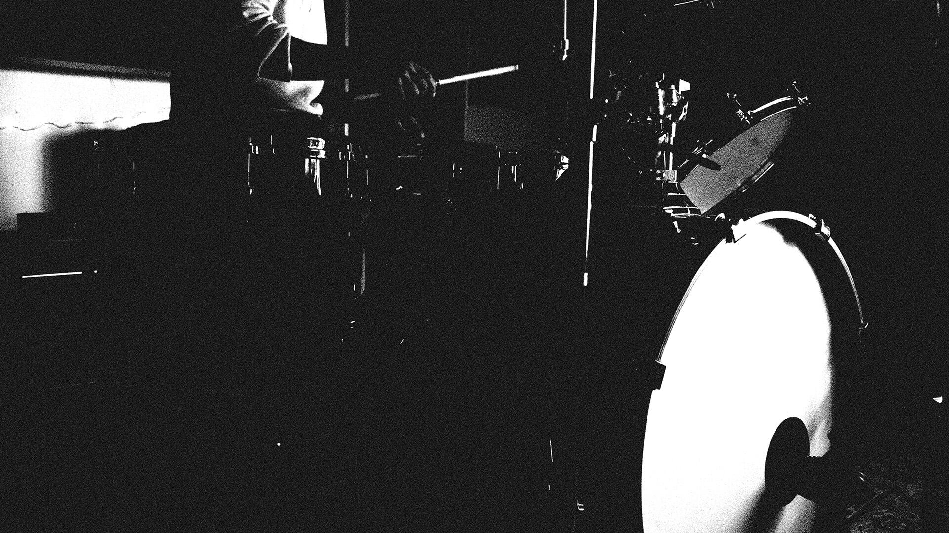 High-contrast black and white image of a drummer playing a full drum kit, capturing gritty drum samples and analog textures. Ideal for vintage audio enthusiasts and sample pack creators.