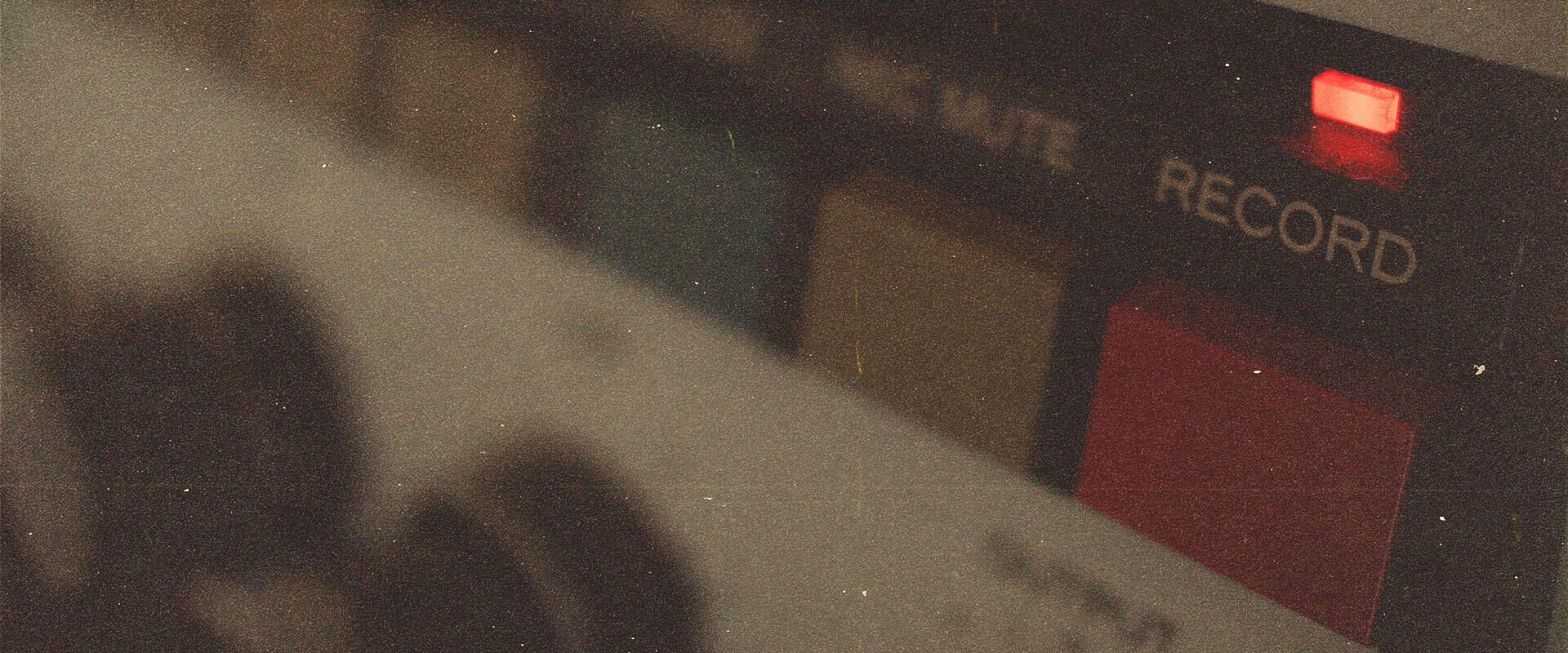 Close-up of a retro tape machine featuring an illuminated red 'Record' button, perfect for capturing vintage audio textures and distressed sound for samples packs.